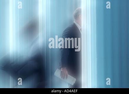 soft focus photo of business executives entering and leaving office building Stock Photo