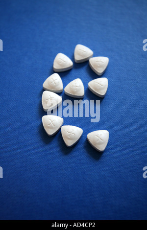 Triangle shaped ecstasy tablets on a blue background. Stock Photo