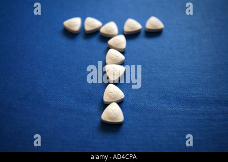 Triangle shaped ecstasy  tablets on a blue background. Stock Photo