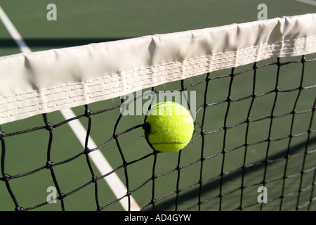 A tennis ball stuck in a tennis net Stock Photo