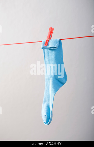 A blue sock hanging on a clothesline Stock Photo