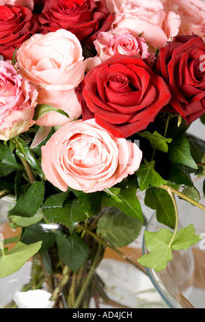 A bouquet of red and pink roses in a vase on a table Stock Photo