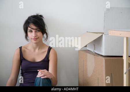 Young woman sitting next to cardboard boxes Stock Photo