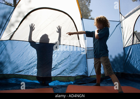 A young boy pointing to a shadow on a tent Stock Photo