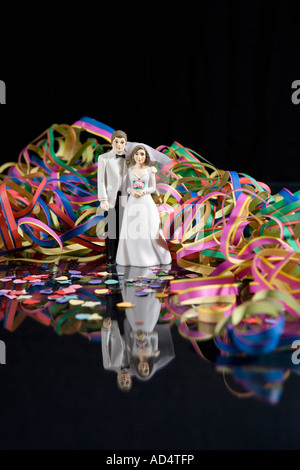 Streamers and confetti surrounding a figurine of a bride and groom Stock Photo