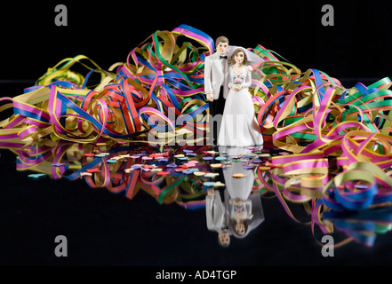 Streamers and confetti surrounding a figurine of a bride and groom Stock Photo