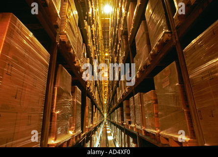 Products shrink-wrapped on pallets stacked full in a high bay automated modern warehouse Stock Photo