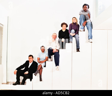 Group of adults sat on staircase Stock Photo