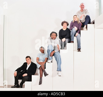Group of adults sat on staircase Stock Photo