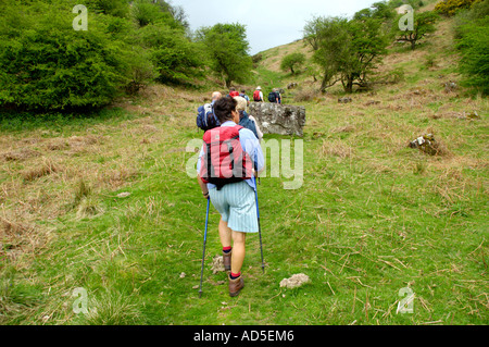 Group of walkers on footpath walking up steep slope in the Black Mountain near Abergavenny Monmouthshire South Wales UK Stock Photo