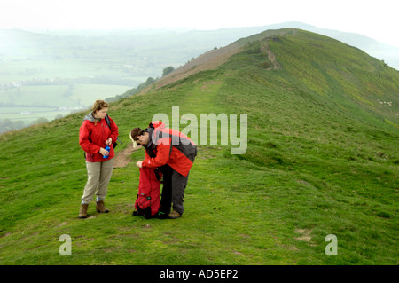 Young adults walking on footpath to summit of Skirrid Fawr mountain Abergavenny Monmouthshire South Wales UK Stock Photo