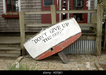 A boat part forms a sign saying DON'T GIVE UP THE SHIP in Martha's Vineyard in front of a small shop Stock Photo