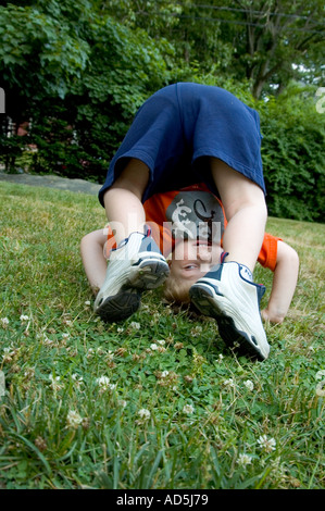 Small Child looking through legs upside down playing Stock Photo - Alamy