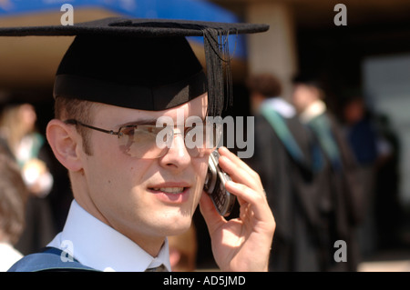 Male Graduate of Aberystwyth University with mortar board talking on mobile phone Stock Photo