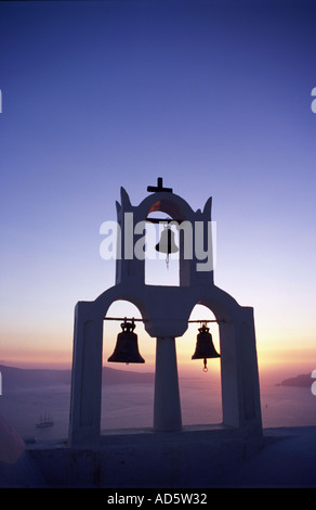 3 Bells on top of Church at sunset in silhouette, Santorini Stock Photo