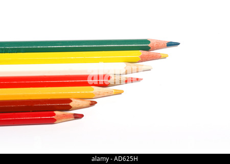 A row of sharpened colored pencils in red, yellow, green, and white arranged diagonally on a white background. Stock Photo
