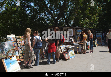 People visiting the Street Market selling Paintings and Books along the River Seine Paris France EU Europe Stock Photo