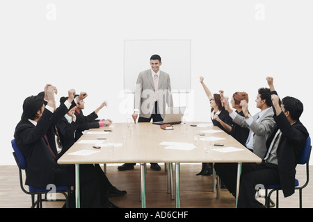 Group of business executives raising their hands at a presentation Stock Photo