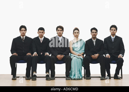 Portrait of a young woman sitting between five young men Stock Photo