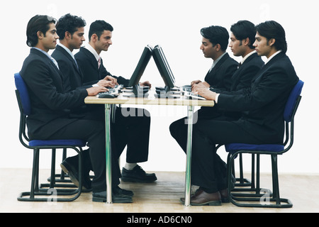 Side profile of a group of businessmen working on computers in an office Stock Photo