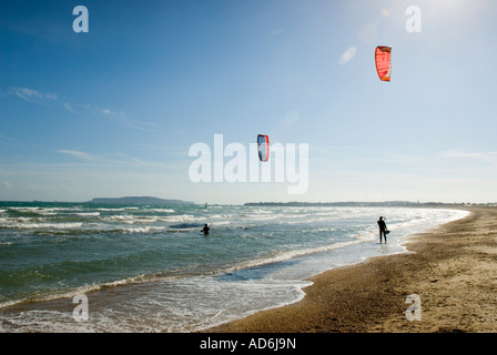 Kite surfers on Weymouth beach in Dorset, UK. With Portland in the background on a very windy but sunny day.Popular surfing area Stock Photo