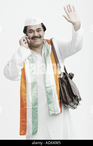Portrait of a mature man talking on a mobile phone waving his hand Stock Photo