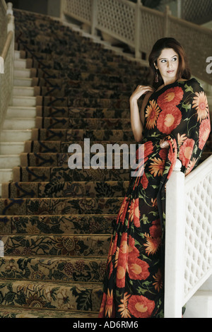 Young woman leaning against a hand rail Stock Photo