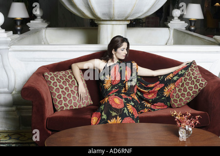 Young woman sitting on a couch Stock Photo