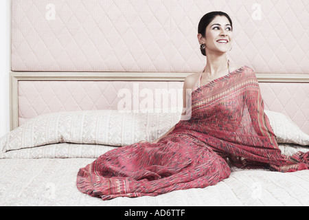 Young woman sitting on the bed Stock Photo