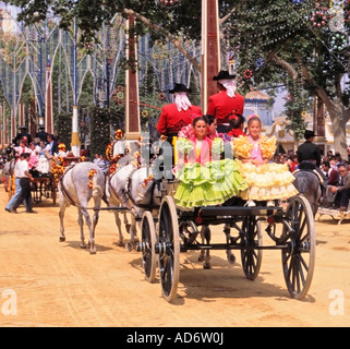 Jerez Horse Fair, Feria del Caballo, young girls on carriage dressed in trajes de gitanas (gypsy dresses), Jerez de la Frontera, Andalusia, Spain Stock Photo