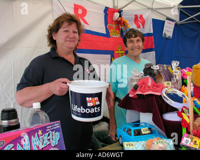 women running a tombola in aid of the RNLI charity fund raising for a good cause Shoreham by Sea West Sussex Stock Photo