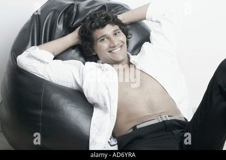 Portrait of a young man sitting on a bean bag Stock Photo