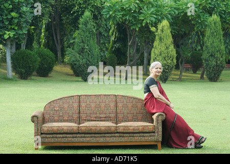 Side profile of a mature woman sitting on a couch outdoors Stock Photo