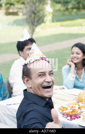 Portrait of a senior man sitting at a table smiling Stock Photo