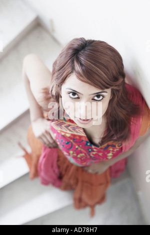 Portrait of a young woman standing on stairs Stock Photo