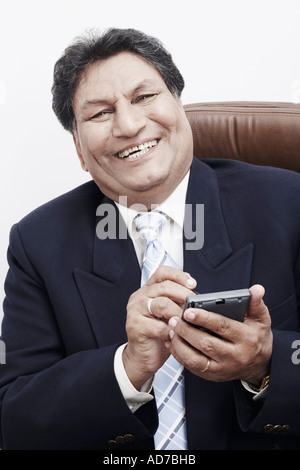 Portrait of a businessman operating a personal data assistant Stock Photo