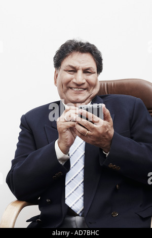 Portrait of a businessman operating a personal data assistant Stock Photo
