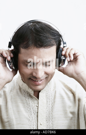 Close-up of a mid adult man wearing headphones listening to music Stock Photo