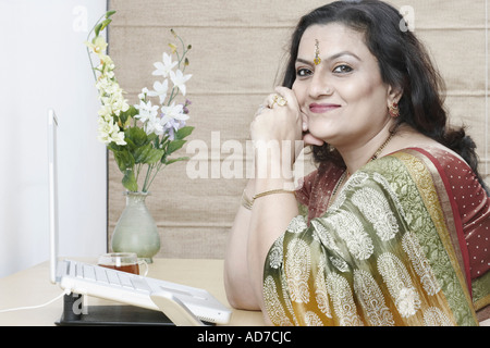 Side profile of a mature woman sitting in front of a laptop Stock Photo