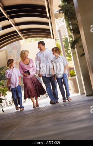 Family walking together to church and carrying Bibles Stock Photo