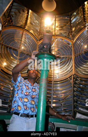 The mantle of the Hopetown lighthouse finally lights casting a warm glow over the Fresnel lens walled tip of the lighthouse Stock Photo