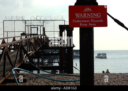 Warning sign on fire damaged West Pier, Brighton, East Sussex, UK. Stock Photo