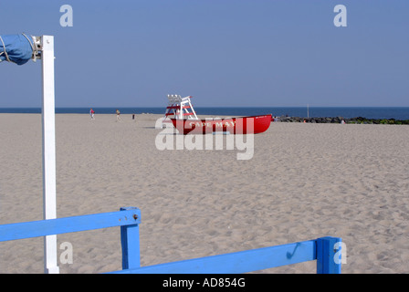 Bright Red Lifeboat and Empty Lifeguards Raised Chair on Beach at Cape May New Jersey United States America Stock Photo