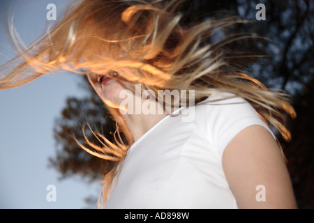 Young woman tossing her long blond hair outdoors, view from below Stock Photo