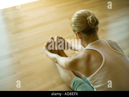 Woman doing seated forward bend Stock Photo