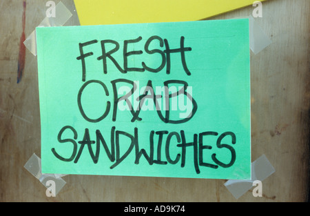 Neatly handwritten sign stuck to a window stating Fresh crab sandwiches Stock Photo