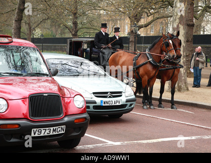 Pair and carriage waiting at traffic lights in the Mall in London's Westminster Stock Photo