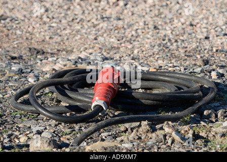 Extension cord for three-phase current laying on the ground Stock Photo