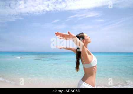 Beach wellness young woman doing a yoga excercise Stock Photo
