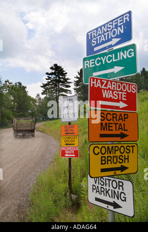 Signs at a recycling center point the directions to various recycling locations Stock Photo